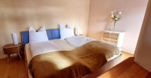 1 dormitorio con 1 cama grande y un jarrón de flores en natürliches Umfeld für Genießer Wohnung Teichblick, en Bleckede