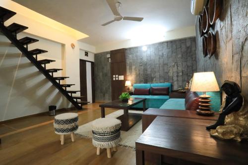 a living room with a couch and a staircase at BANIPARK SERVICE APARTMENT in Jaipur