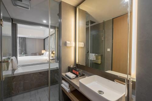 uma casa de banho com um lavatório e um espelho em Riverdale Residence Xintiandi Shanghai em Xangai