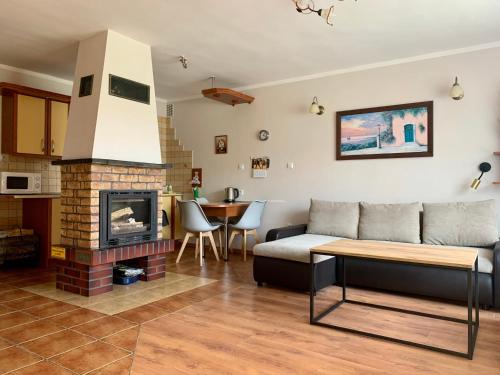 a living room with a couch and a fireplace at Fonica - Domek Apartament in Łeba
