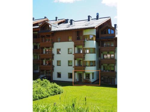 an apartment building with a green lawn in front of it at Ferienwohnung Königsleiten 77 - Top 34 in Königsleiten