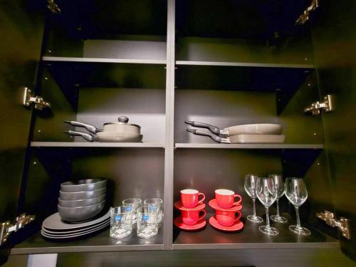a cupboard with plates and wine glasses and dishes at Edge Central Pattaya BJ 88 in Pattaya Central