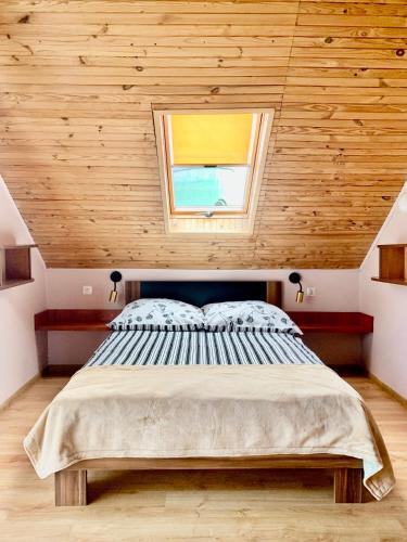 a bedroom with a large bed with a window at Fonica - Domek Apartament in Łeba
