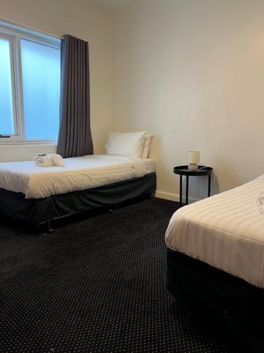 Habitación de hotel con 2 camas y ventana en Star Bar Cafe & Hotel, en Launceston