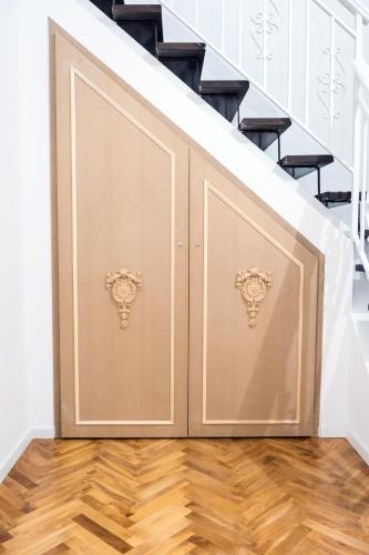 a pair of wooden doors on the bottom of stairs at Althea in Viareggio