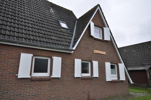 a brick house with white windows and a roof at Nr 31 - Ferienhaus Am Yachthafen in Carolinensiel