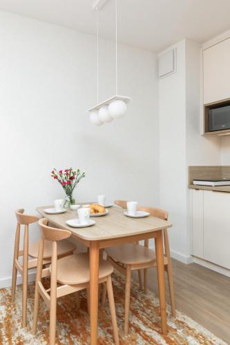 a dining room with a wooden table and chairs at Sun & Beach Apartments Bel Mare with Parking by Noclegi Renters in Międzyzdroje