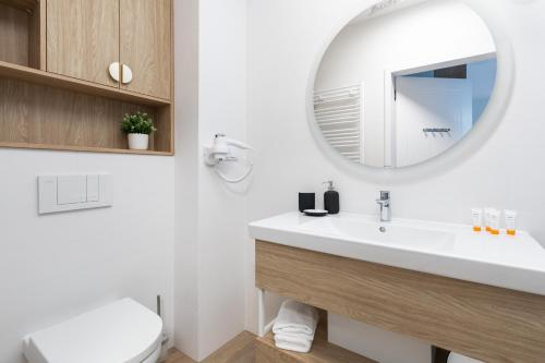 a bathroom with a white sink and a mirror at Sun & Beach Apartments Bel Mare with Parking by Noclegi Renters in Międzyzdroje