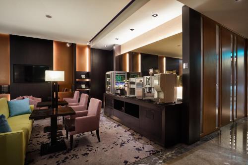 a hotel room with a bar with chairs and a coffee maker at The Tango Hotel Taipei Nanshi in Taipei