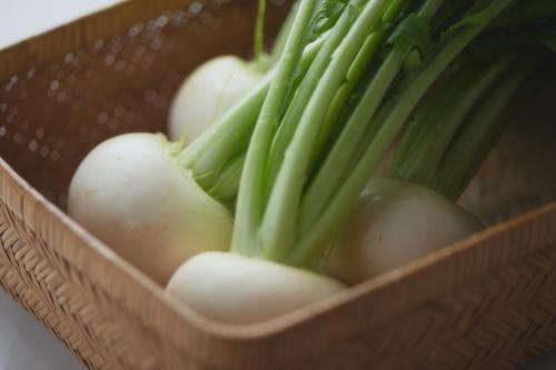 a container filled with onions and green vegetables at くろしお想 in Shirahama