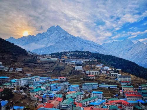 a town on a hill with a mountain in the background at Hotel hillten in Namche