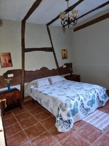 1 dormitorio con 1 cama con edredón azul y blanco en Corias Casona junto al Narcea en Corias