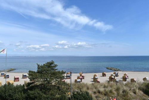 einen Strand mit einem Haufen Stühle und dem Meer in der Unterkunft Villa Seestern Ferienwohnung Nr 04 in Niendorf