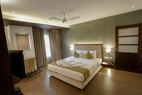 a bedroom with a large bed and a television at Woodbine Foliage in Malappuram