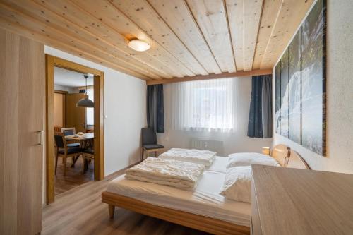 a bedroom with two beds and a table in it at Haus Aventurin in Fiss