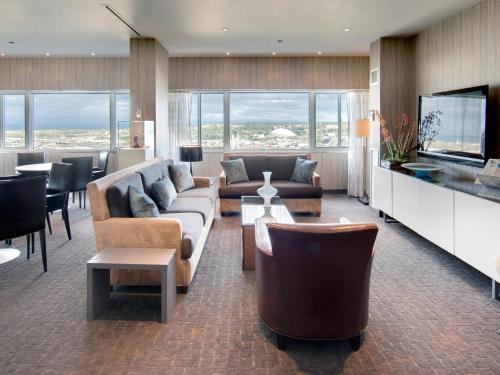 a living room with a couch and chairs and a tv at Hotel Murano in Tacoma
