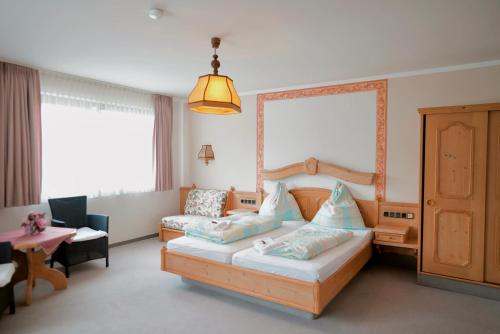 ein Schlafzimmer mit einem Bett, einem Stuhl und einem Tisch in der Unterkunft In & Out Boardinghaus in Stolberg