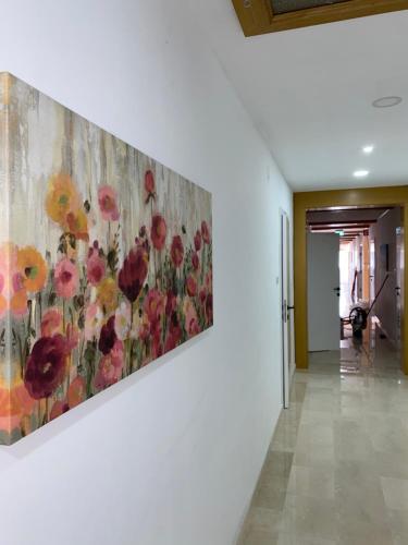 a painting of flowers on a wall in a hallway at Die Herberge in Podersdorf am See