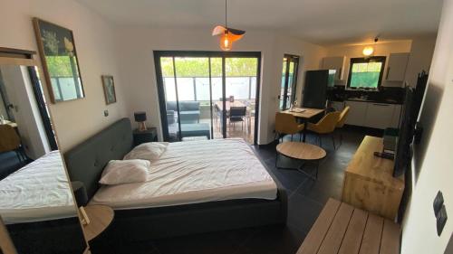 Il comprend une chambre avec un lit et une cuisine avec un bureau. dans l'établissement Nice, splendide appartement 4p résidentiel, terrasse vue piscine , Garage, à Nice