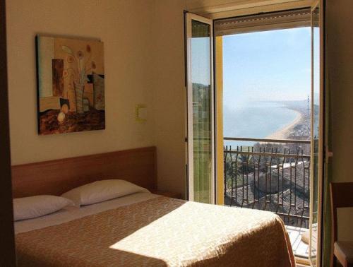 a bedroom with a bed and a view of the ocean at Hotel Dei Sette in Vasto