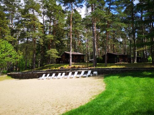 a group of chairs sitting on a beach in front of a cabin at Osrodek Wypoczynkowy RAJ in Mostowo