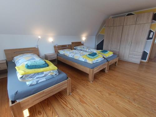 twee bedden in een kamer met houten vloeren bij Ferienhaus in der Schleife 1 in Rendsburg