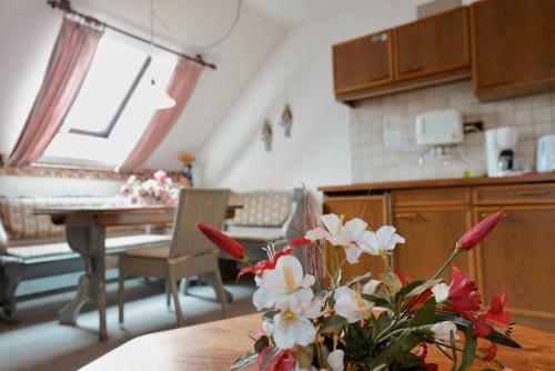 eine Küche mit einem Tisch und einer Vase aus Blumen in der Unterkunft In & Out Boardinghaus in Stolberg