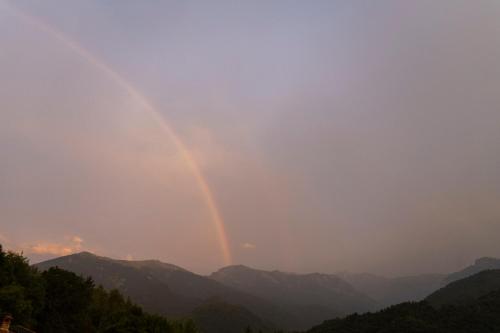 a rainbow in the sky over the mountains at B&B immerso nel bosco con area benessere esclusiva nel cuore delle montagne - IDUEVAGAMONDI in Chiusa di Pesio