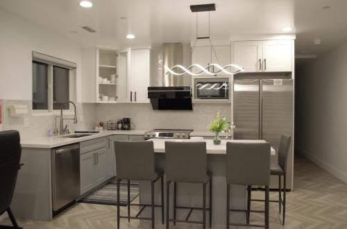 una cucina con armadi bianchi e tavolo con sedie di Dimond Abode Vacation Rental #2 a Oakland
