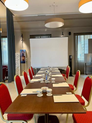 a conference room with a long table and red chairs at Grand Hotel Palace in Ancona