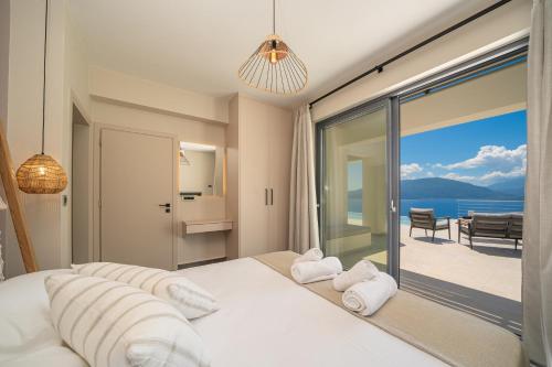 a bedroom with a bed and a view of the ocean at Villa Fortuna in Ayia Evfimia