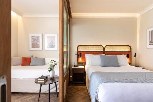 a hotel room with two beds and a table at Kerkyra Blue Hotel & Spa by Louis Hotels in Corfu Town