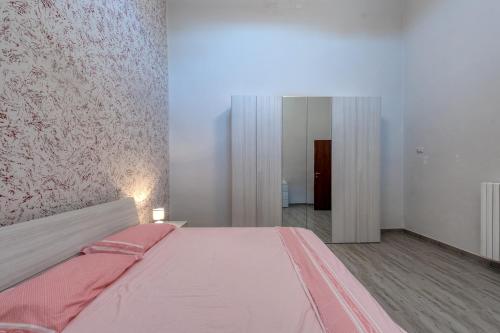 a bedroom with a large bed with pink sheets at Casa vacanze Petra in Squinzano