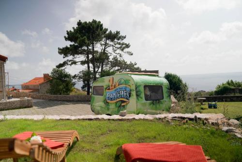 a green trailer parked in a yard at Aldea Soma in Carnota