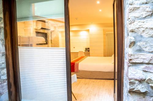 a room with a bedroom with a bed and a window at Hotel Rio Bidasoa in Hondarribia