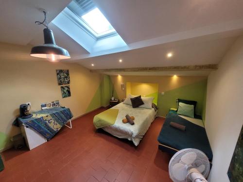 een slaapkamer met een bed, een bank en een raam bij Moulin Gaillard in Bédarieux