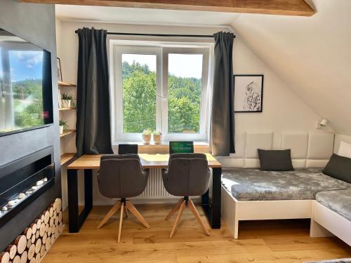 a room with a desk and a bed and a window at Molinaro Apartmány Jeseníky in Karlovice