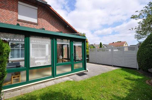 a conservatory on the side of a house at Nr 52 - Ferienhaus Marie-Ulfers-Weg in Carolinensiel