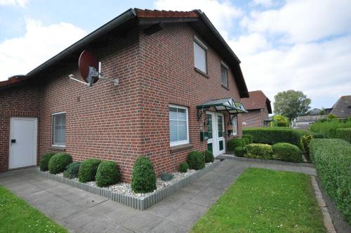 a red brick house with a white door at Nr 52 - Ferienhaus Marie-Ulfers-Weg in Carolinensiel
