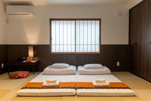 two beds in a room with a window at Irodori Hotel YANAGI in Fukuoka