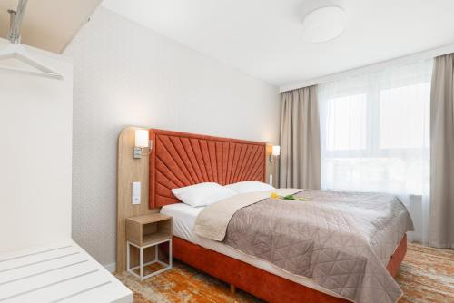 a hotel room with a bed and a window at Sun & Beach Apartments Bel Mare with Parking by Noclegi Renters in Międzyzdroje