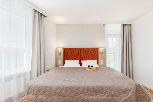 a bedroom with a bed with two cats sitting on it at Sun & Beach Apartments Bel Mare with Parking by Noclegi Renters in Międzyzdroje