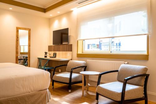 a bedroom with a bed and chairs and a table at Hotel Rio Bidasoa in Hondarribia