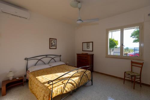 a bedroom with a bed and a window and a chair at L'isola di Gianni by Ortigia Apartments in Plemmirio