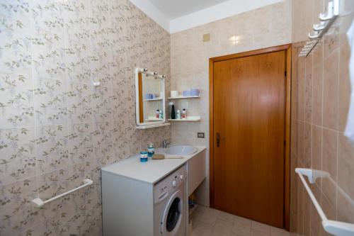 a bathroom with a washing machine and a sink at L'isola di Gianni by Ortigia Apartments in Plemmirio