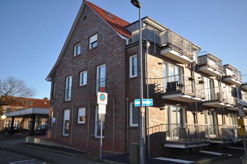 un edificio in mattoni rossi con balconi su una strada di Nr 57 - Ferienwohnung Mühlenstraße a Carolinensiel