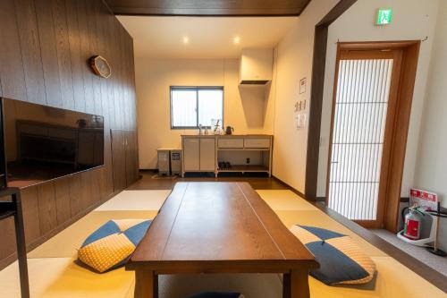 a living room with a wooden table and a kitchen at Irodori Hotel YANAGI in Fukuoka