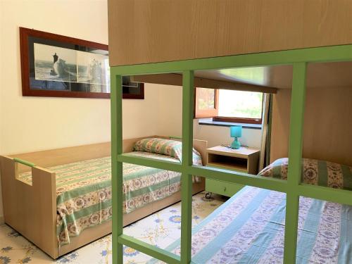 a bedroom with two bunk beds and a window at Casa Bouganville in Pollara