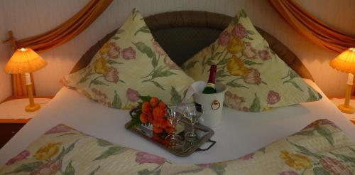 a bed with two pillows and a tray of flowers on it at Landhaus Heide in Schneverdingen