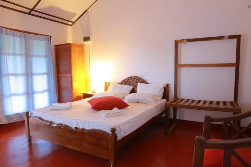 una camera da letto con un cuscino rosso di Blissbay @ the rock a Nilaveli